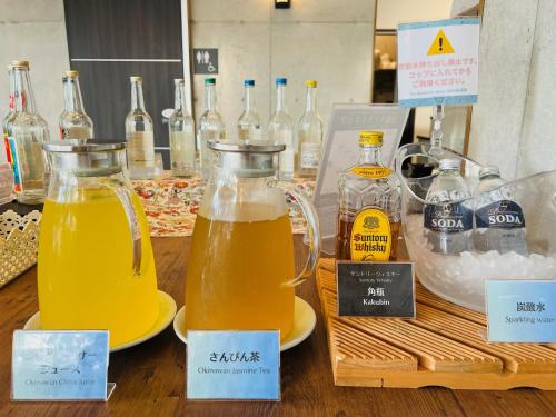 a table with two pitchers of beer and bottles of wine at The BREAKFAST HOTEL PORTO Ishigakijima in Ishigaki Island