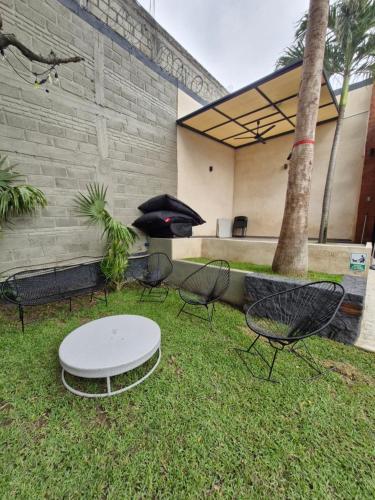 a group of chairs and a table in the grass at Casa Ohana Morelos in Tlayacapan