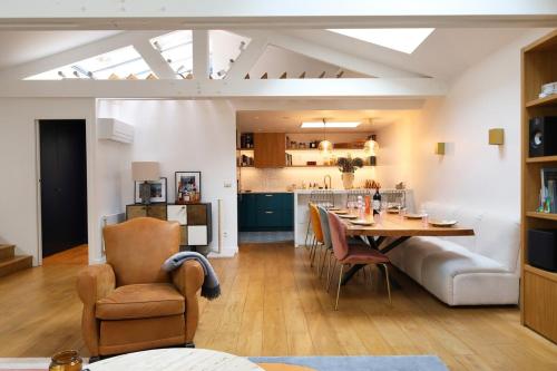 Il comprend un salon et une cuisine avec une table et des chaises. dans l'établissement Luxueux 3 chambres | Hammam | cœur du Marais, à Paris
