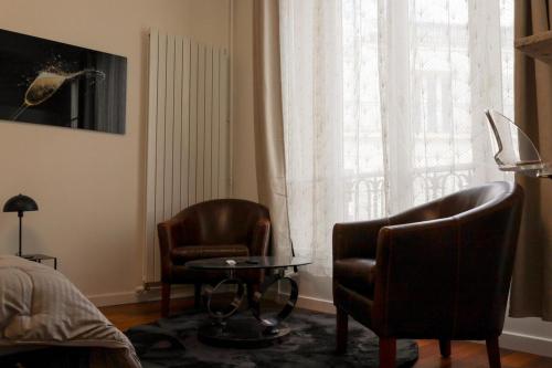 - une chambre avec 2 chaises, une table et une fenêtre dans l'établissement Nouveau studio au cœur de l'Opéra - Paris 1er, à Paris