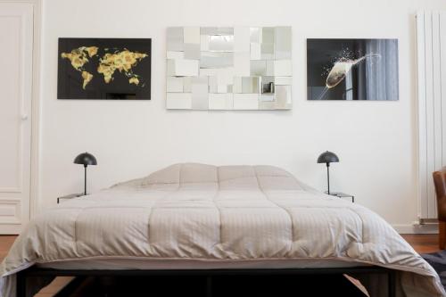 - une chambre avec un lit orné de 3 peintures murales dans l'établissement Nouveau studio au cœur de l'Opéra - Paris 1er, à Paris
