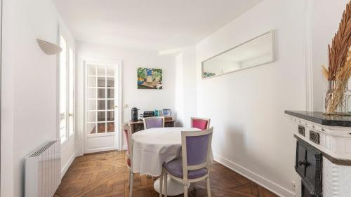 une salle à manger blanche avec une table et des chaises dans l'établissement Spacieux au coeur du Marais | 4 personnes, à Paris