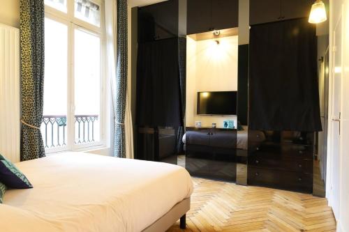 une chambre d'hôtel avec un lit et une télévision dans l'établissement St Georges proche Opéra et la Basilique sacrée, à Paris