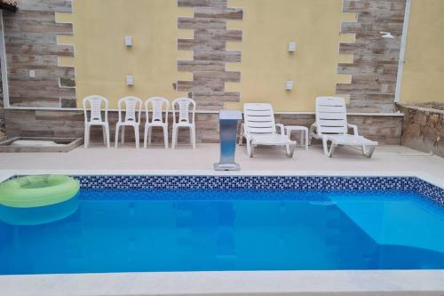 a pool with chairs and a frisbee next to it at Espaço Bem Bom in Andaraí