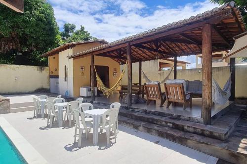 a patio with white chairs and tables and a pavilion at Espaço Bem Bom in Andaraí
