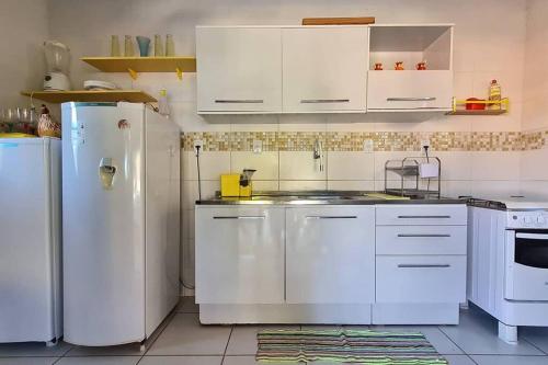 a kitchen with white appliances and white cabinets at Espaço Bem Bom in Andaraí