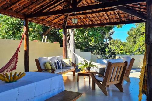 a patio with a couch and chairs under a pergola at Espaço Bem Bom in Andaraí