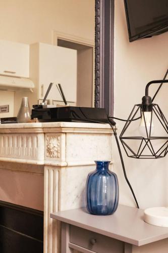 un vase bleu assis au-dessus d'une table dans l'établissement Studio confortable et moderne au cœur de Paris, à Paris