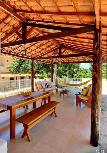 a wooden pergola with a table and benches on a patio at Espaço Bem Bom in Andaraí