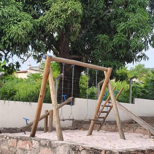 a wooden swing set in front of a tree at Espaço Bem Bom in Andaraí
