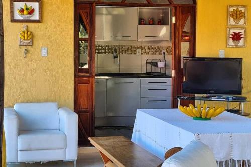 a living room with a table and a kitchen at Espaço Bem Bom in Andaraí