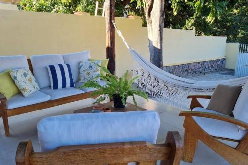 a hammock on a patio with a couch and chairs at Espaço Bem Bom in Andaraí