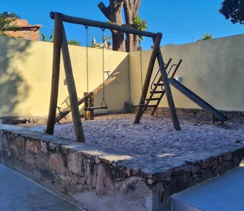 a swing set in a playground with a wall at Espaço Bem Bom in Andaraí