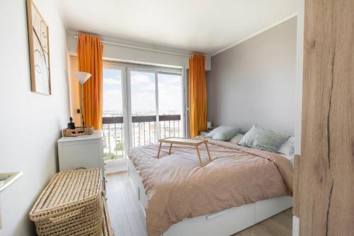une chambre avec un lit et une grande fenêtre dans l'établissement Appartement Élégant à Montmartre, à Paris