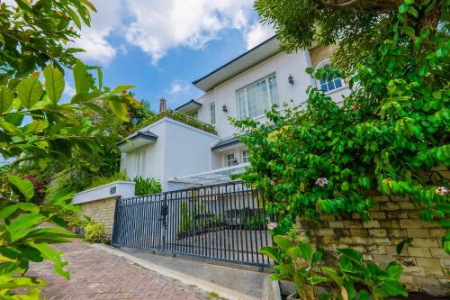 a white house with a wrought iron gate at Viki Nest by SooBali 4BR in Umalas