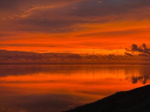 a sunset over a large body of water at Villa Karel Mauritius Beach house in Riambel