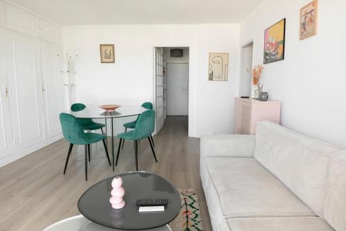 un salon avec un canapé, une table et des chaises dans l'établissement Appartement Élégant à Montmartre, à Paris