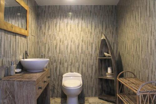 a bathroom with a white toilet and a sink at Family Villa, Shared Pool, Garden, Rice Field & Jungle Views in Ubud