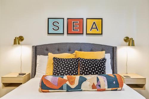 a bedroom with a bed with two lamps and three pictures on the wall at Travelers Dream, Walk to Space Needle, Firepit, cornhole in Seattle