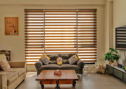a living room with a couch and a coffee table at 家太幸福民宿 in Xingjian