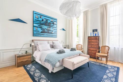 - une chambre blanche avec un lit et un tapis bleu dans l'établissement Appartement luxueux / historique proche bon marché, à Paris