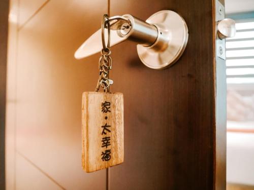 a tag on a keychain hanging from a door at 家太幸福民宿 in Xingjian