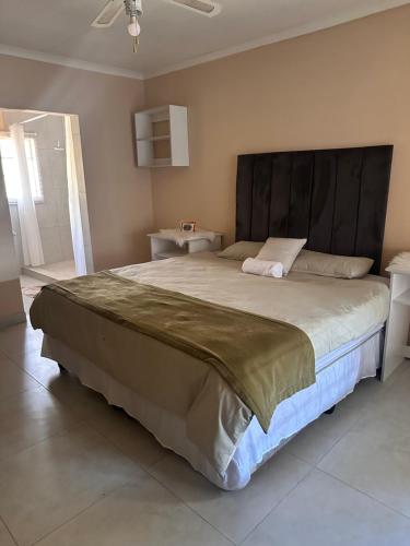 a large bed with a large headboard in a bedroom at Cebos oasis in Mataffin