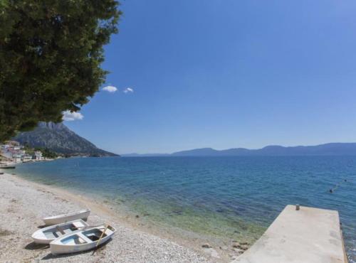 a boat sitting on a beach next to the water at Beachfront Apartments Andrijević in Brist