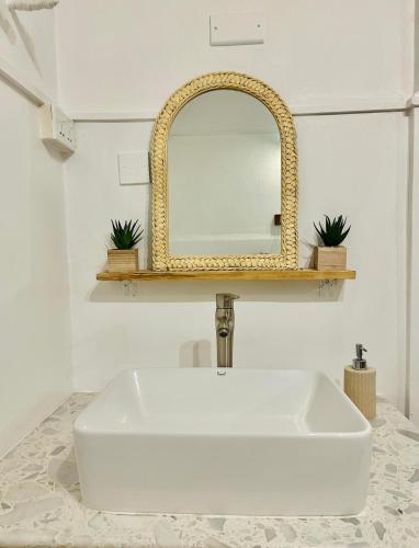a bathroom with a white sink and a mirror at Horizon Haven, Mauritius in Flic-en-Flac