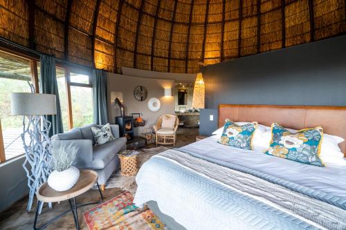a bedroom with a bed and a living room at Gondwana Game Reserve in Kleinberg