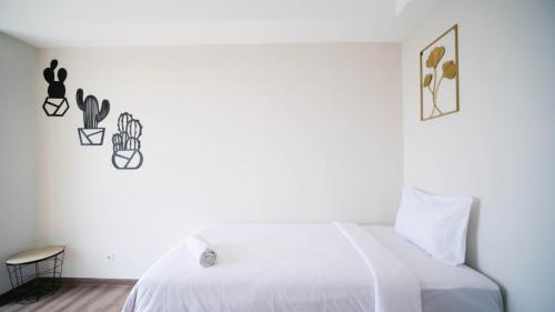 Ένα ή περισσότερα κρεβάτια σε δωμάτιο στο Minimalist with Beautiful View 2BR at Grand Sungkono Lagoon Apartment By Travelio