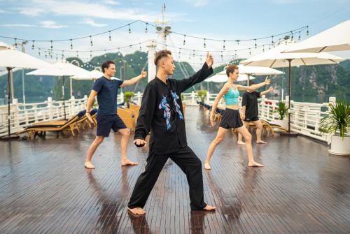 a group of people dancing on a deck at The Au Co Cruise - Managed by Bhaya Cruise in Ha Long