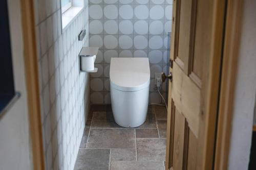 a bathroom with a toilet in a small room at vacation house huit 8 in Koshu