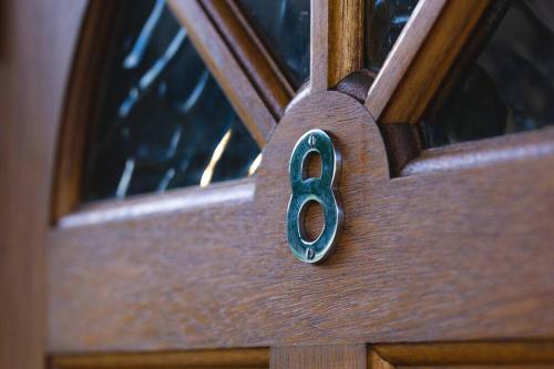 a wooden door with a bronze door knocker on it at vacation house huit 8 in Koshu
