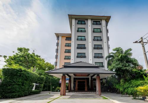 a tall building with a building with a gate in front at The Wing Design Hotel in Bangkok