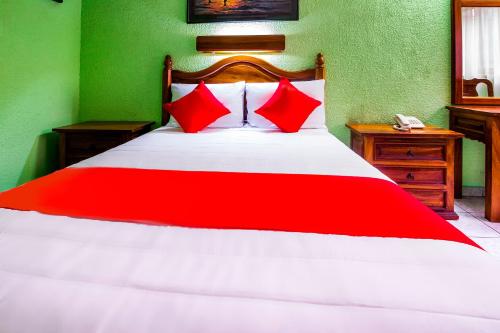 a red and white bed in a green bedroom at Hotel Canada, Guadalajara in Guadalajara