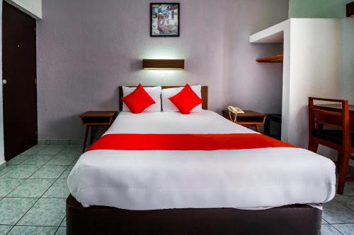 a bedroom with a large bed with red pillows at Hotel Canada, Guadalajara in Guadalajara