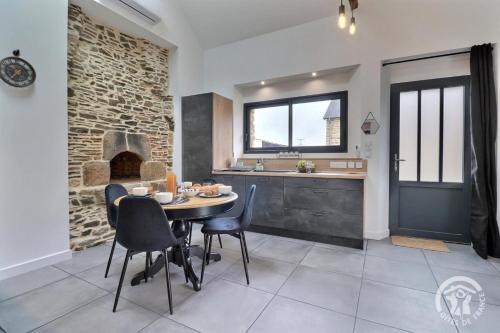 a kitchen and dining room with a table and chairs at Le four in Saint-Georges-de-Chesné