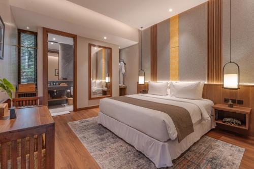 a bedroom with a large bed and a bathroom at Plataran Puncak Residences in Puncak