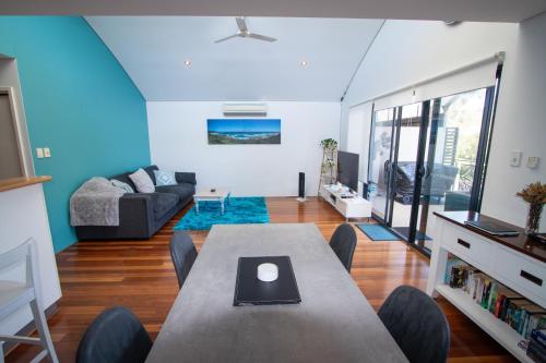 a living room with a table and a couch at Margaret River Retreat on Fearn in Margaret River Town