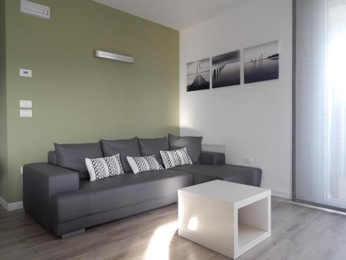 a living room with a gray couch and a white table at Flyingaway in Borso del Grappa