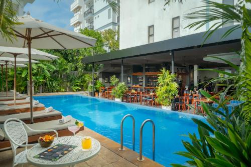 a pool with tables and chairs next to a building at Onederz Siem Reap in Siem Reap