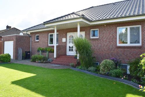 een rood bakstenen huis met een groen gazon bij Ferienhaus im Bleitz in Wrestedt