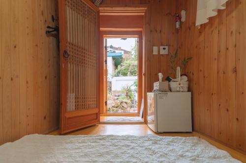 a kitchen with a refrigerator and an open door at Beautiful Garden Fine Day House in Jeonju