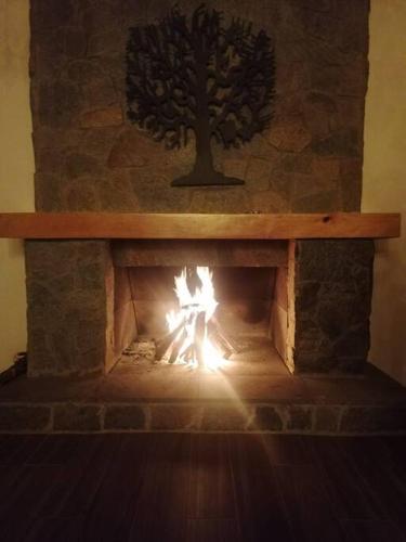 a brick fireplace with a fire in it at Villa Alejandra Cabaña in Tapalpa