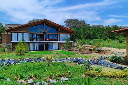 a house with a garden in front of it at Villa Alejandra Cabaña in Tapalpa