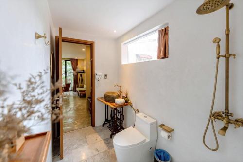 a bathroom with a toilet and a window at Nam An Mama Villa Hoi An in Hoi An