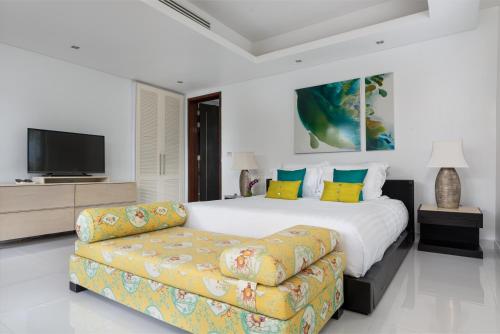 a bedroom with a large bed and a couch at Lotus Samui Luxury Beach Villas in Mae Nam