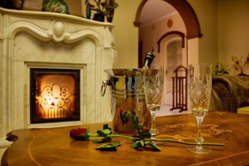 a table with two champagne glasses and a fireplace at Villa Wellness in Budapest