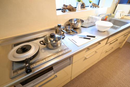 a kitchen counter with pots and pans on a stove at 花の宿 別府 in Beppu